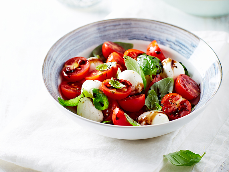 Mozzarella and cherry tomato salad drizzled with balsamic vinegar