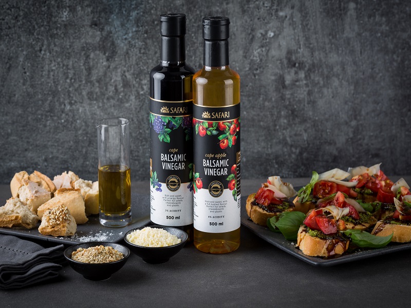 SAFARI balsamic vinegar styled with fresh ingredients on a dark table