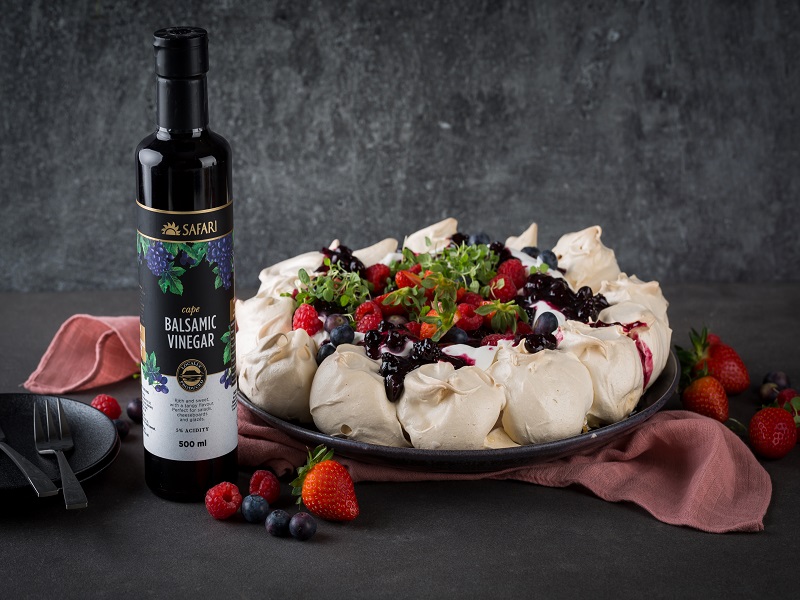 Pavlova topped with cream and mixed berry balsamic jam
