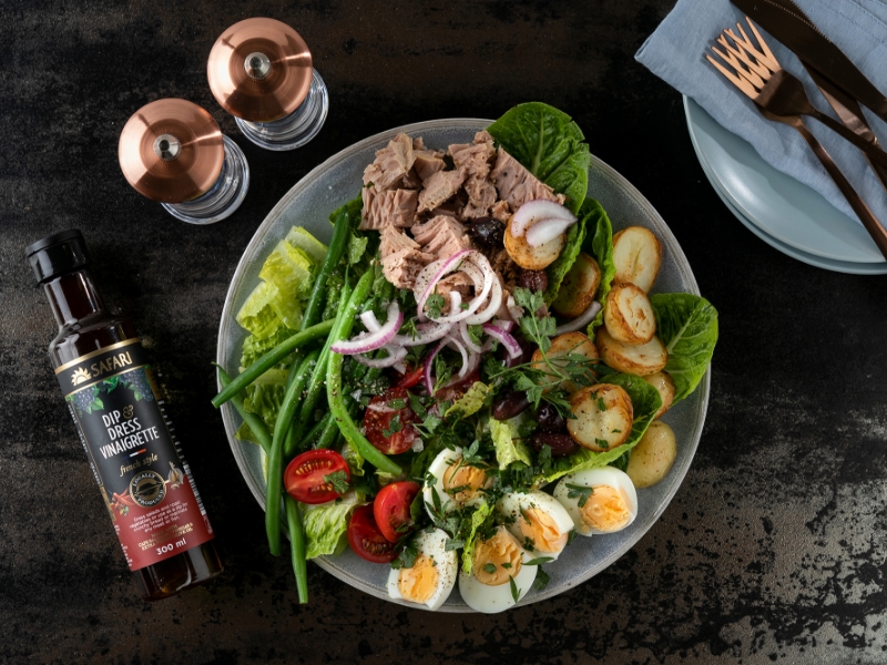 Salad Nicoise plated with egg, tomato and greens