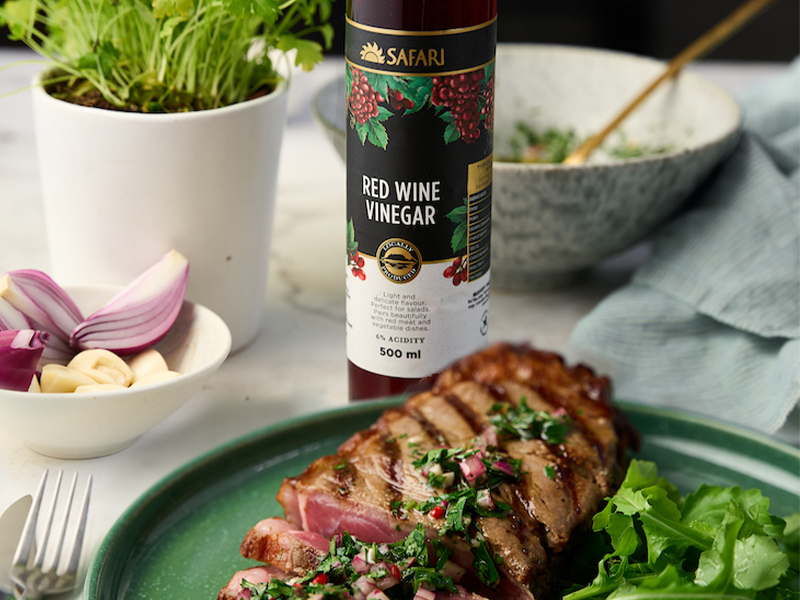 Grilled steak served with a bottle of SAFARI Organic Red Wine Vinegar